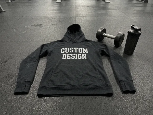 Fitted fitness hoodie with CUSTOM DESIGN print on a gym rubber floor with a dumbbell
