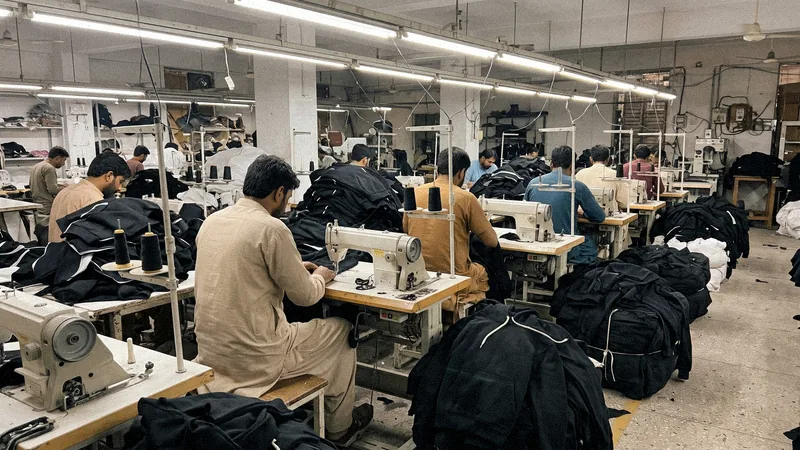 Workers stitching hoodies at the Luxury Stitch factory, faces turned away