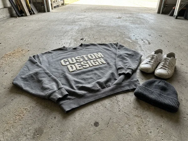 Oversized streetwear crewneck sweatshirt with puff print on a concrete floor