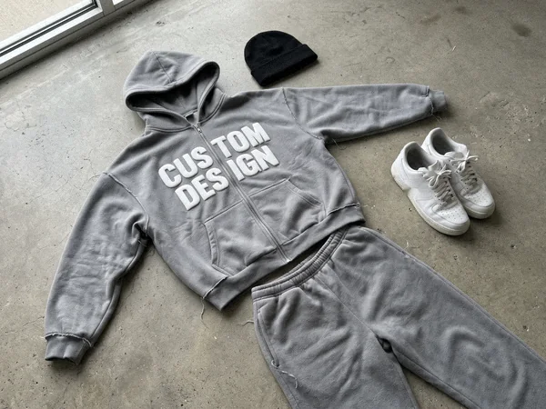 Heavyweight fleece zip hoodie and joggers sweatsuit with puff print on a concrete floor