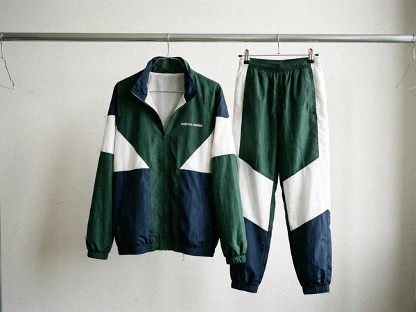 Color-block nylon windbreaker tracksuit with mesh lining hanging on a rail