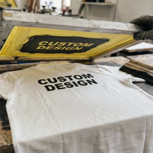Screen printed CUSTOM DESIGN graphic on the back of a polo shirt on a print table