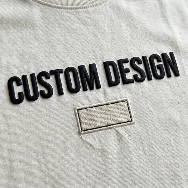 T-shirt combining puff print and embroidery that reads CUSTOM DESIGN