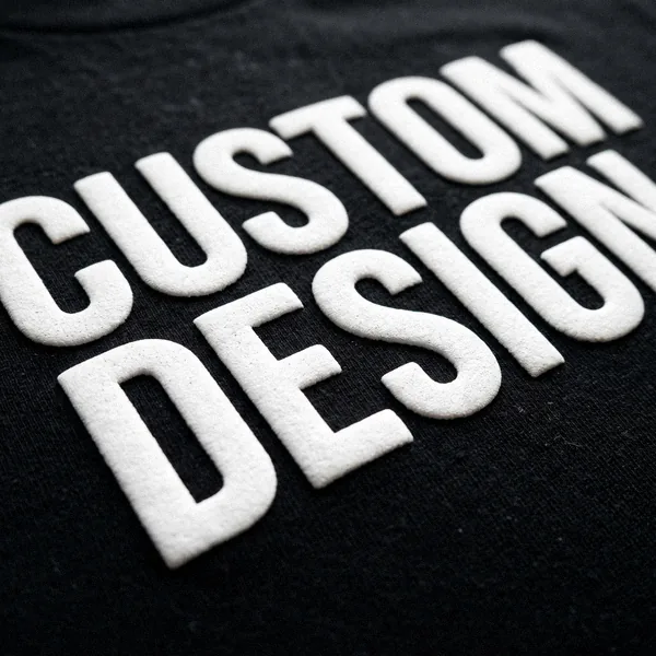 Close-up of raised puff print reading CUSTOM DESIGN on a T-shirt