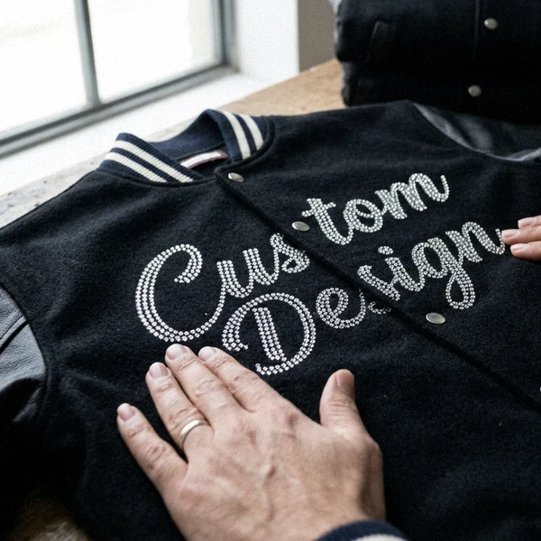 Rhinestone logo on a black varsity jacket